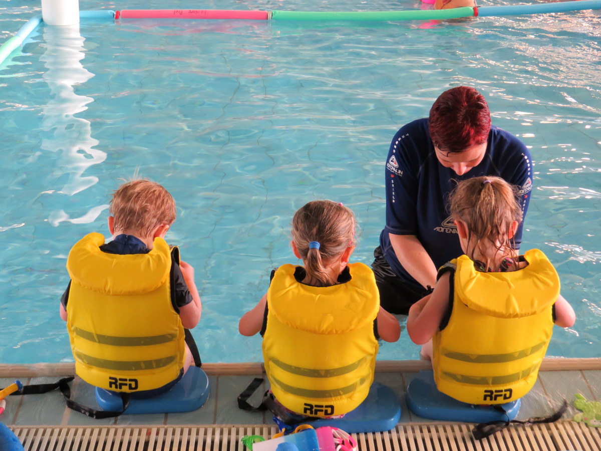 Instructor teaching pre school kids to swim